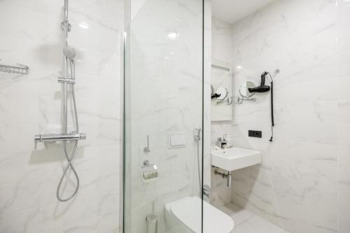 a bathroom with a shower and a toilet and a sink at Brosse Garden in Tbilisi City