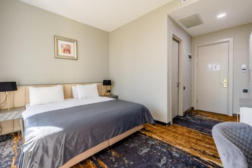 a bedroom with a bed and a table and a chair at Brosse Garden in Tbilisi City