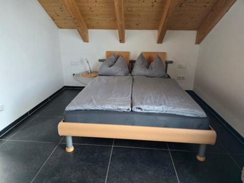 a large bed in a room with a wooden ceiling at Haus Motorsport in Bad Saulgau