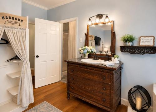 a bathroom with a sink and a mirror at Historic Mansion-King Suite-The Blue Jay in Fort Smith