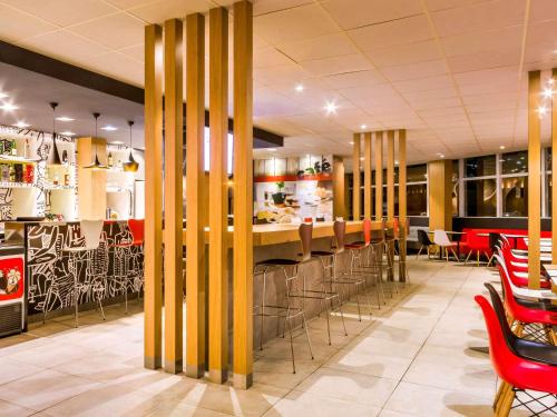 a restaurant with a bar with stools at ibis Marilia in Marília