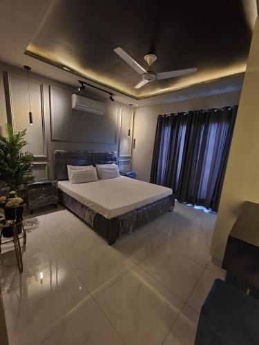 a bedroom with a bed and a ceiling fan at 1 Bed Modern Apartment, Pool, Gym, Cinema in Lahore