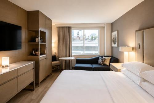 a hotel room with a large bed and a television at Sheraton Duluth Hotel in Duluth