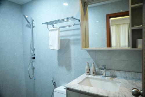 a bathroom with a sink and a shower with a mirror at The R One in Male City