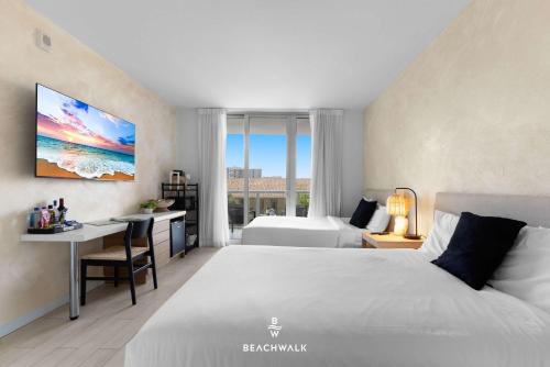 a bedroom with a bed and a desk and a bed and a room with at Pininfarina Studio Intracoastal View in Hallandale Beach