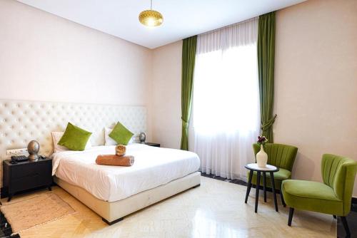 a bedroom with a bed and a green chair at Villa zitoun in Aït Bou Zguia