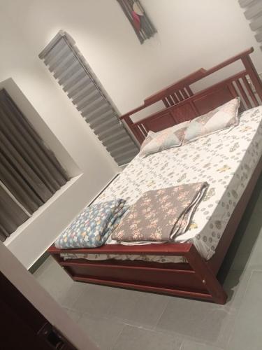 a bed with a wooden frame in a room at Coorg Family Villa in Gonikoppal