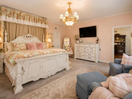 a bedroom with a large white bed and a chandelier at Historic Mansion-Blushing Rose in Fort Smith