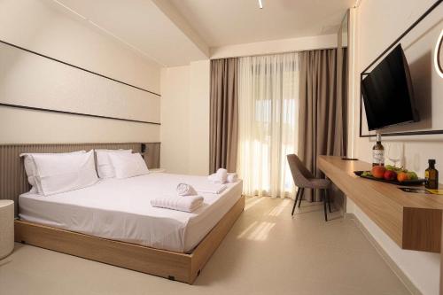 a hotel room with a bed and a television at Sophe Boutique Stay 2 in Kallithea Halkidikis