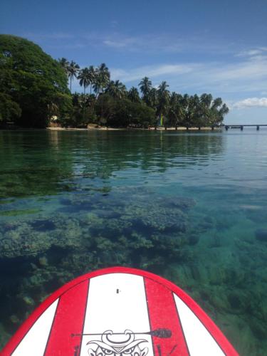 a red and white paddle board in the water at Naveria Heights Lodge in Savusavu