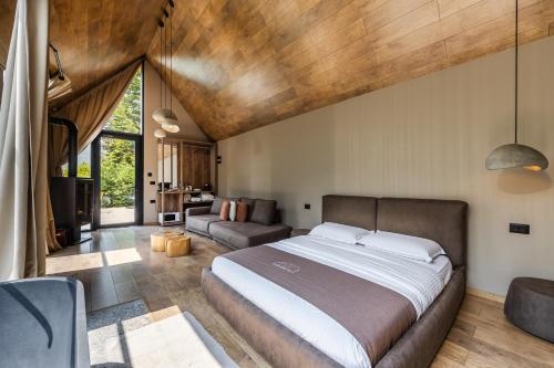 a bedroom with a large bed and a couch at North Alpine Villas in Bogë