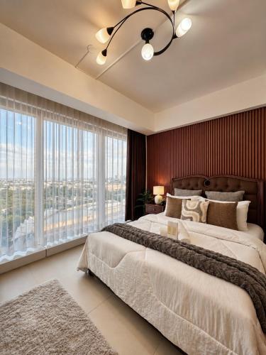 a bedroom with two beds and a large window at Aeon Towers Davao Condotel near Abreeza Ayala Mall in Davao City