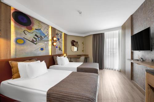 a hotel room with two beds and a tv at Best Western Plus Khan Hotel in Antalya