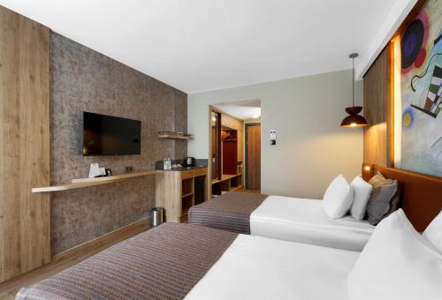 a hotel room with two beds and a tv at Best Western Plus Khan Hotel in Antalya