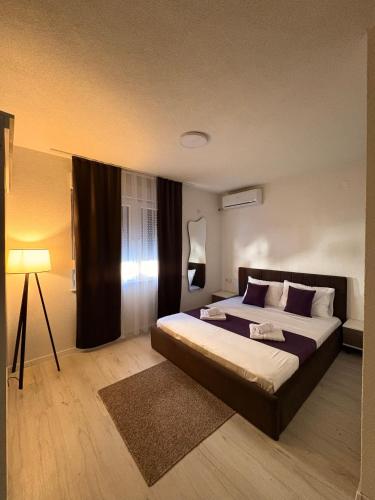 a bedroom with a large bed and a lamp at Hotel AKSA in Prizren