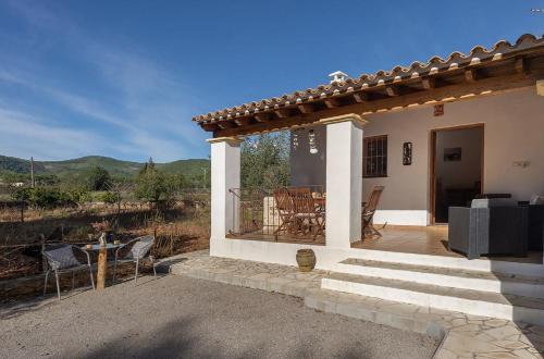 a small white house with a patio with a table and chairs at Villa Can Turrent in Sant Carles de Peralta