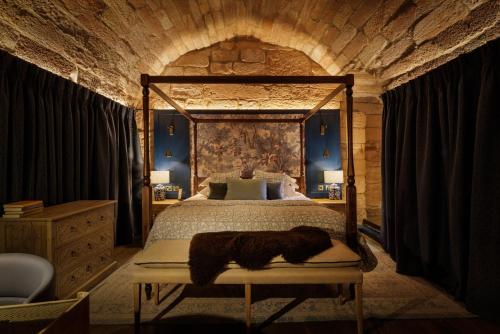 a bedroom with a large bed with a wooden frame at Dalhousie Castle in Bonnyrigg