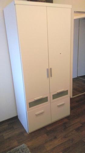 a white cabinet with four drawers and a mirror at Ferienwohnung Familie Perl in Immenhausen