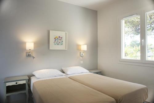 a bedroom with two beds and a window at Appartements des Joncas in Martigues