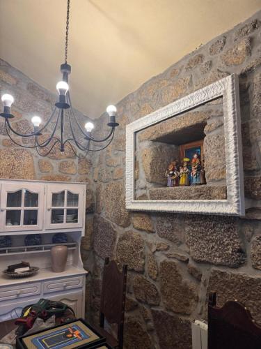 a room with a stone wall with a picture on the wall at Casa da Costeira in Figueiró