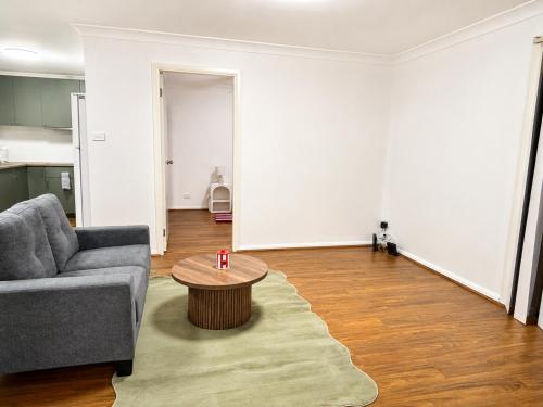 a living room with a couch and a coffee table at 21A Armstrong Place in Schofields