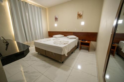 a hotel room with a bed and a bathroom at Hotel Dan Inn Express Foz do Iguaçu By Nacional Inn in Foz do Iguaçu