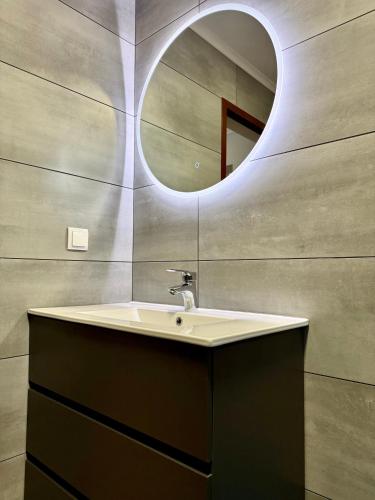 a bathroom with a sink and a mirror at Sea View Pedra Mar in Campanário