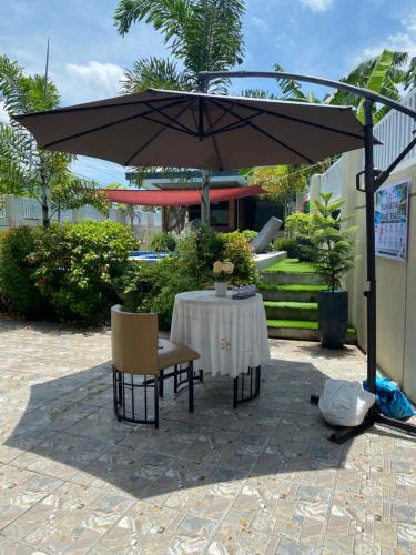a table and chairs under an umbrella on a patio at Casa Sandrine Resort in Malolos
