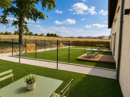 a patio with a table and a view of a field at Le Chai de Canteloup in Yvrac
