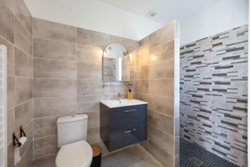 a bathroom with a toilet and a sink at Détente à deux in Saint-Martin-de-Seignanx
