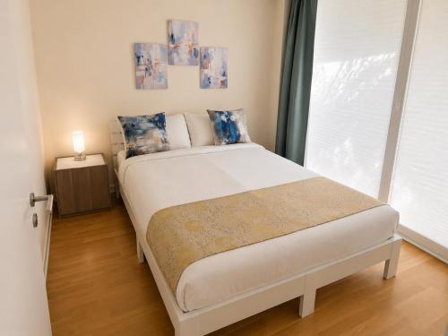 a bedroom with a large white bed with a window at 3-Zimmer-Wohnung mit Terrasse in zentraler Lage in Stuttgart
