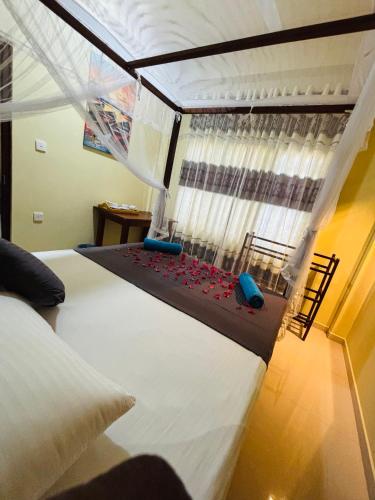 a bedroom with a large bed and a window at Sun land Villa in Hikkaduwa