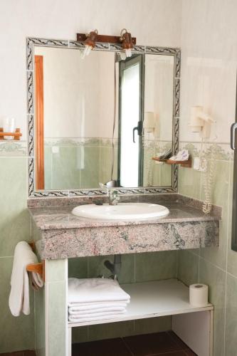 a bathroom with a sink and a mirror at Hostal Guadiana in Ruidera