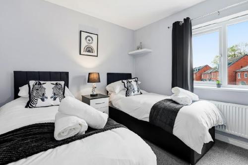 a bedroom with two beds and a window at Home Comforts Await! 3bed 2.5bath in Ellesmere Port