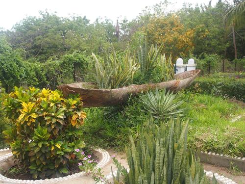 a garden with a stone bowl in the middle of plants at The Old Boma Hotel in Mtwara