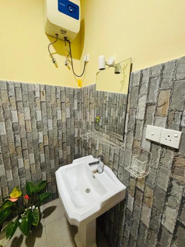 a bathroom with a sink and a phone on the wall at Sun land Villa in Hikkaduwa