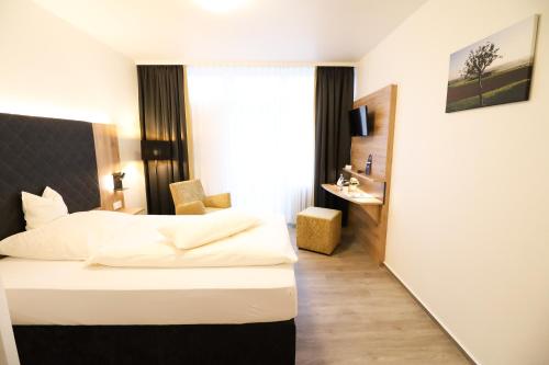 a hotel room with a bed and a window at Hotel Wiehen-Therme in Hüllhorst