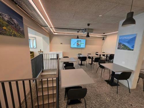 a conference room with tables and chairs and a screen at Regina by GoAcademy in Agno