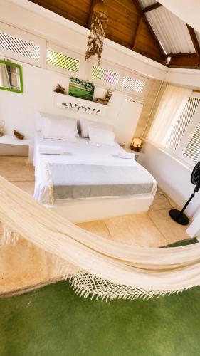 a bed in a room with a hammock in it at Hotel Fuerte Mayal in Puerto Limón