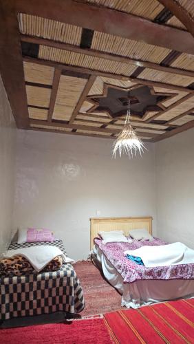 a bedroom with two beds and a ceiling at Dar chez bassou in Imilchil