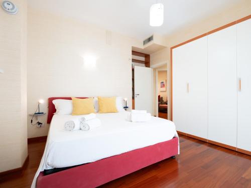 a bedroom with a large bed with white walls and wood floors at Dadu 150 in Bari