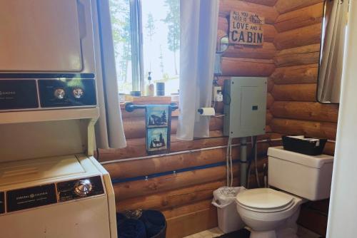a bathroom with a toilet in a log cabin at Cozy Cabin Oxen-Le-Fields Montana in Conner