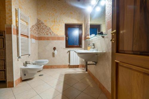 a bathroom with a sink and a toilet and a window at Villa Concipat Rooms in Fonte Nuova