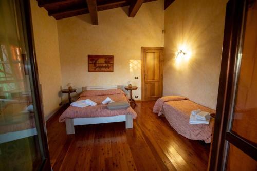 a room with two beds in a room with wooden floors at Villa Concipat Rooms in Fonte Nuova