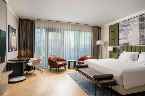 a hotel room with a bed and a desk and chairs at Radisson Blu Leogrand Hotel in Chişinău