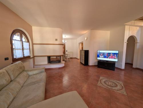 a living room with a couch and a flat screen tv at La Piccola Atene Oasi in Strettoia