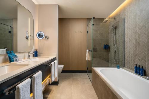 a bathroom with two sinks and a tub and a shower at Radisson Blu Leogrand Hotel in Chişinău