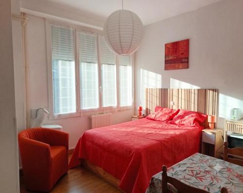 a bedroom with a red bed with a red blanket at Appartement Sauges 16 in Cazaubon