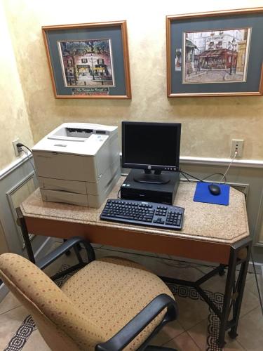 a desk with a computer and a printer and a chair at FairBridge Inn & Suites Kellogg in Kellogg