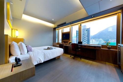 a hotel room with a bed and a desk and window at Wanchai 88 in Hong Kong
